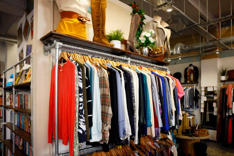A rail of clothes in a second hand vintage charity shop