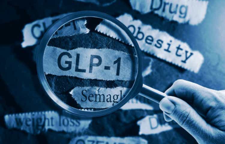 GLP-1 related drugs newspaper headlines with hand and magnifying glass