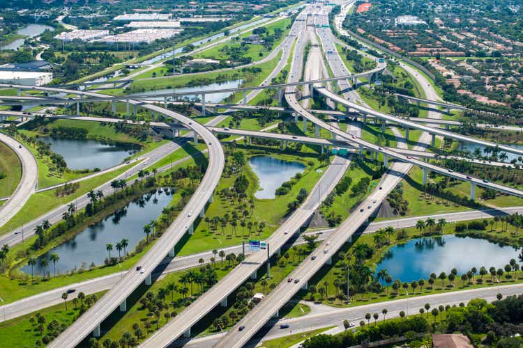 Aerial view of American freeway intersection with fast driving cars and trucks in Miami, Florida. USA city transportation infrastructure