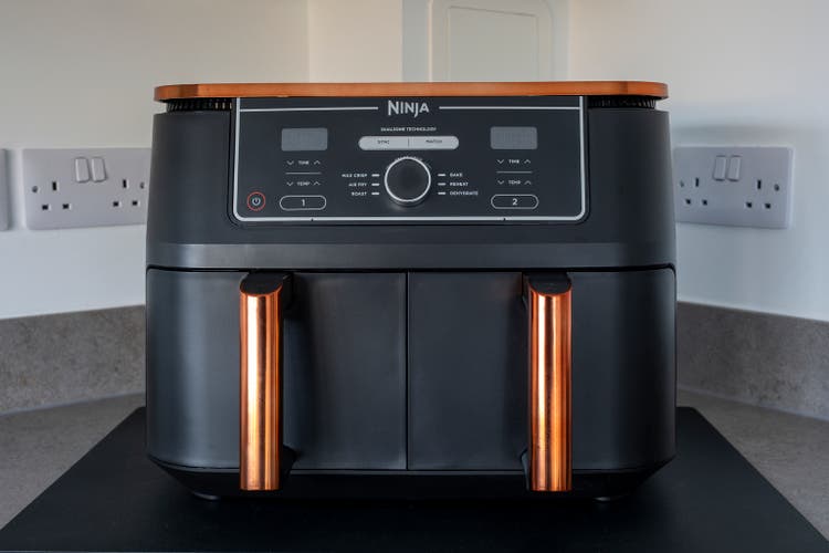 Irvine, Scotland, UK - October 27, 2024: Ninja Brand Deluxe Black & Copper Foodi MAX Dual Zone Air Fryer with Smart Cook System AF451UKDBCP. The ecological alternative to conventional oven cooking and better for the environment.