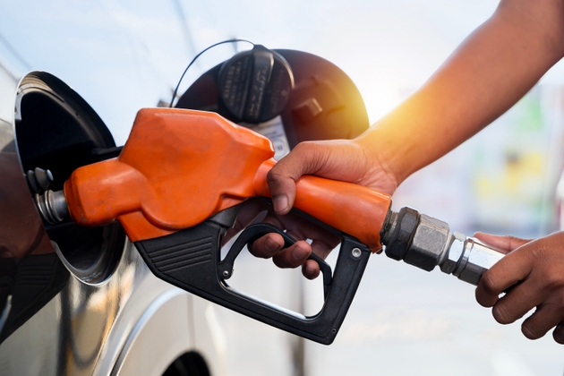 Man handle pumping gasoline fuel nozzle to refuel at petrol station. Transportation and ownership concept.