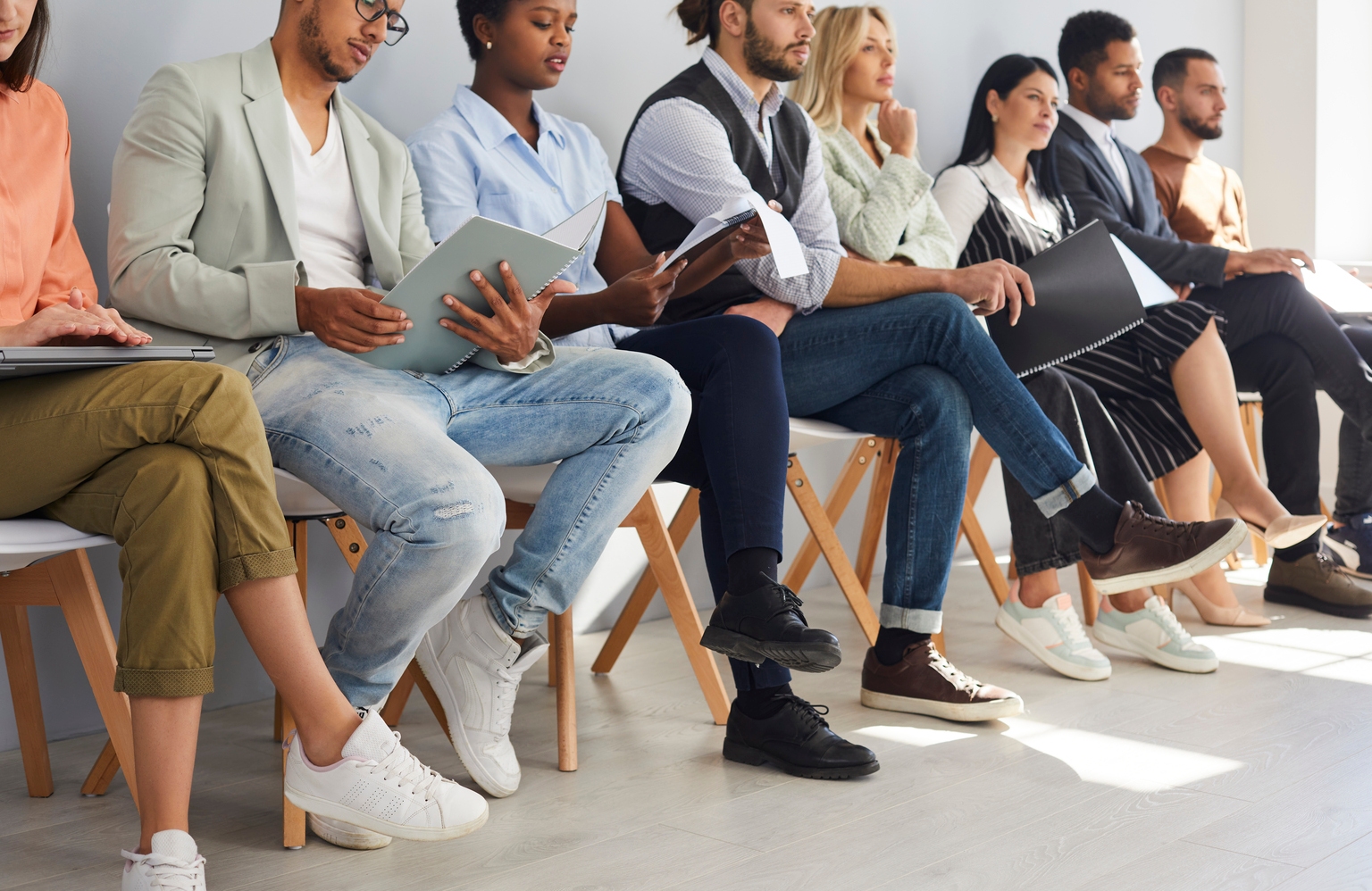 Diverse employees in row wait for company interview