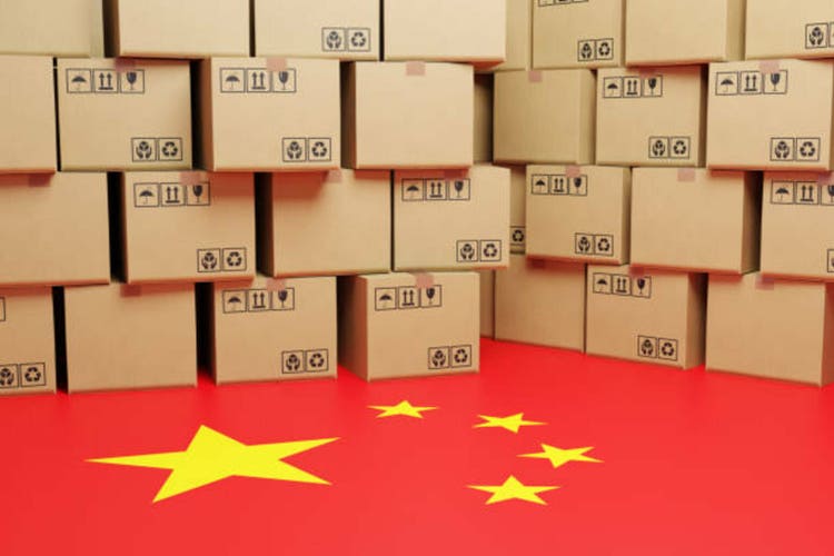 Piles of brown carton boxes on a floor printed with the national flag of the China. Illustration of the concept of Chinese manufacturing, import tax and export tariff