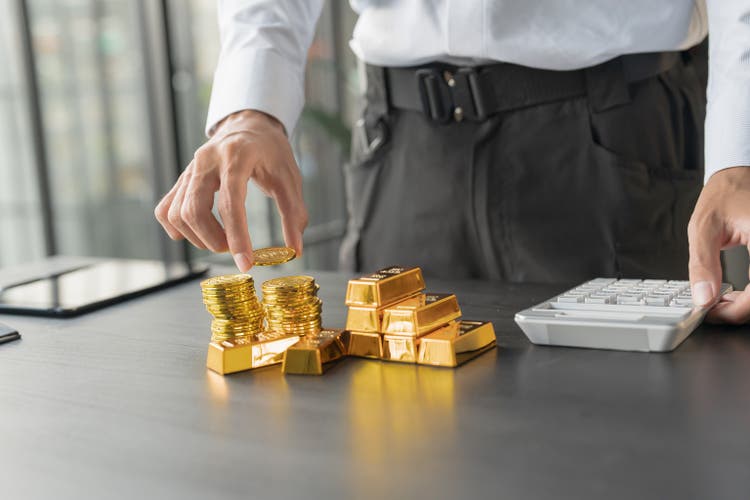 Gold Trading business man hand offering gold Investment in gold mining company or Trading gold on the stock exchange Rising gold prices.