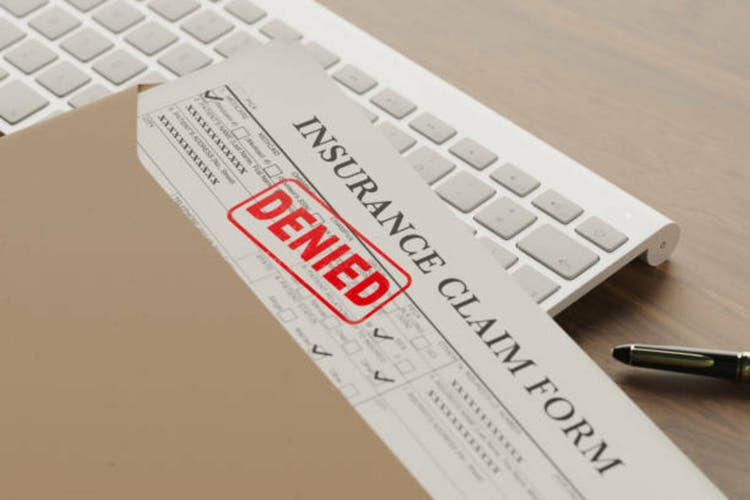 Denied health insurance application form on the table.