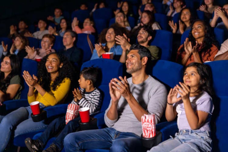 Happy family applauding in the cinema after watching a movie