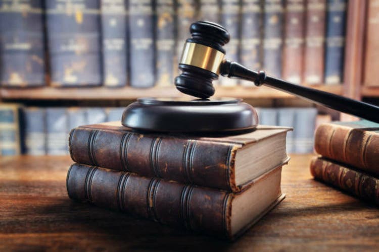 Judge gavel and law books in court background