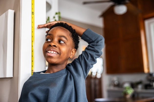 Young boy checking his height on the wall