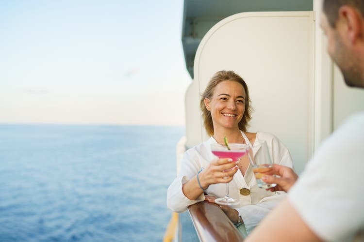 The happy couple toasts with cocktails during the cruise
