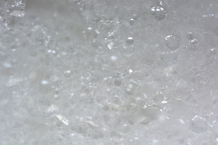Bubbly soap foam background. Soap foam closeup. White foam backdrop.
