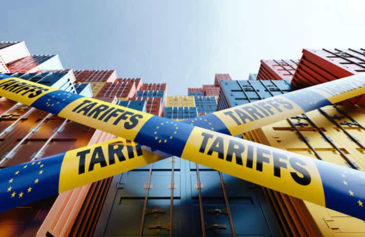 Economic Tariffs Against EU And Trade War Concept - Tariffs Written Tapes With European Union Flags Before Cargo Containers