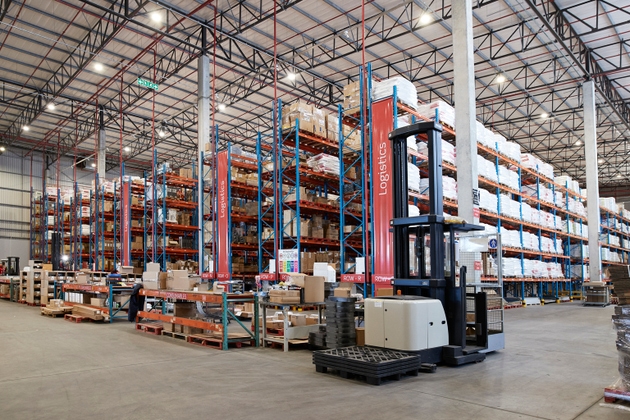 Forklift near shelves of goods for logistics