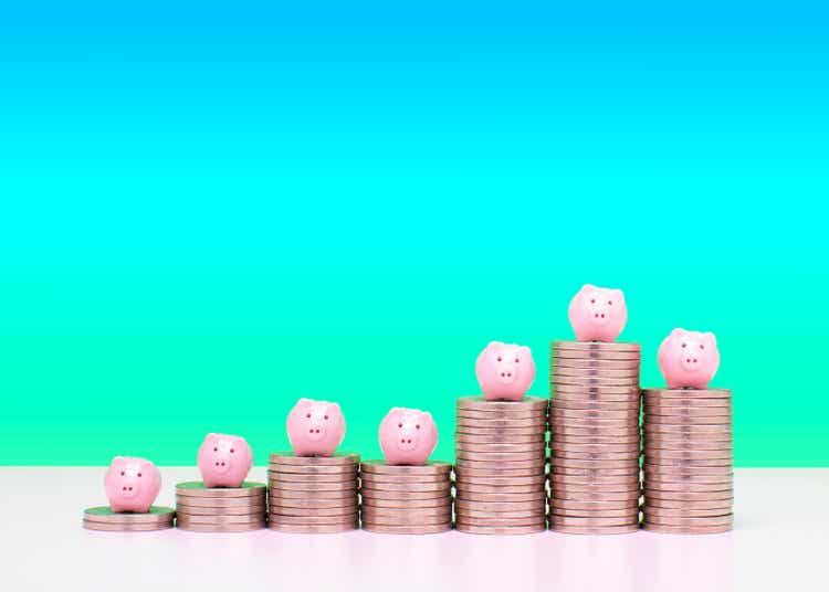 Savings concept - Piggy banks on stacks of coins