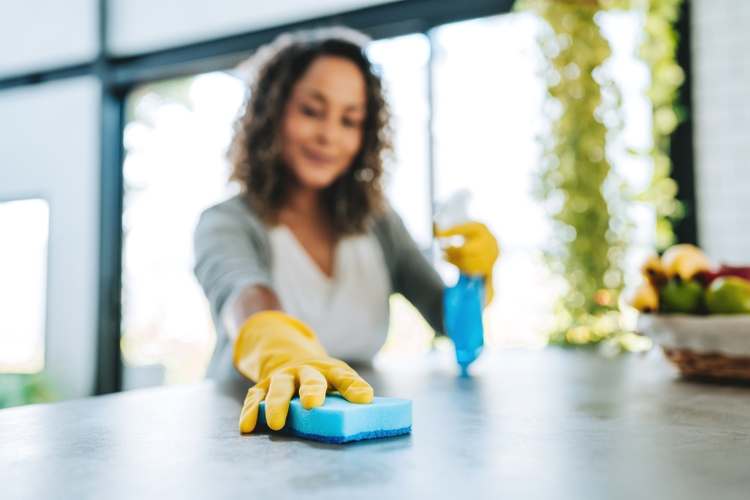 A woman cleans the kitchen counter