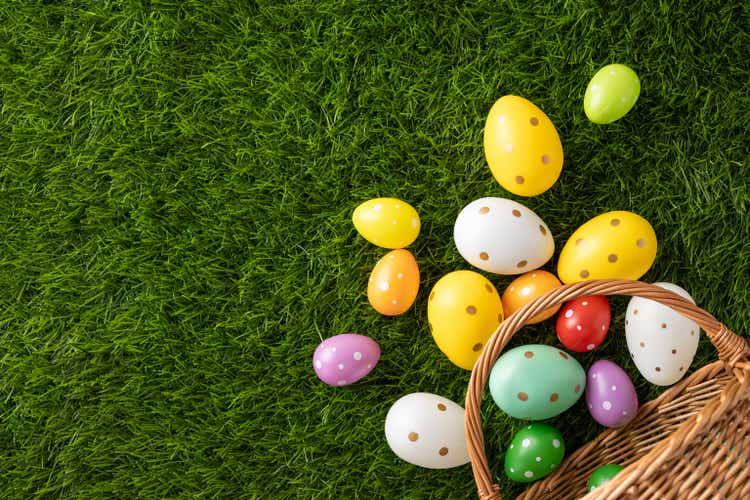 Scattered vibrant Easter eggs on fresh green grass evoke seasonal festivities and traditions
