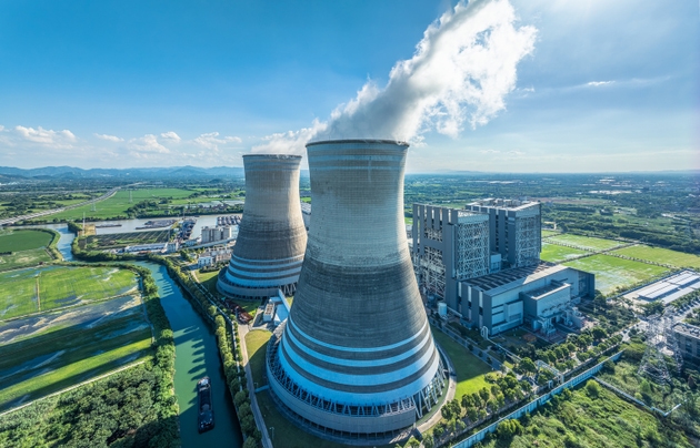Aerial view of power plant with cooling towers and river landscape