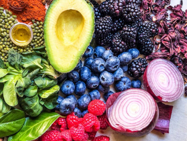 Multi colored vegetables, fruits and legumes on wooden table