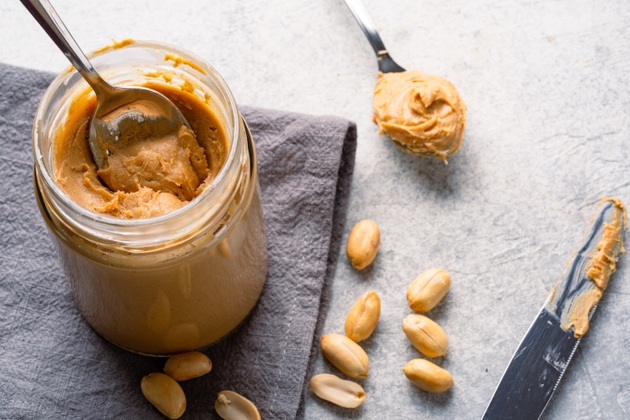 Delicious and healthy peanut butter on vintage background