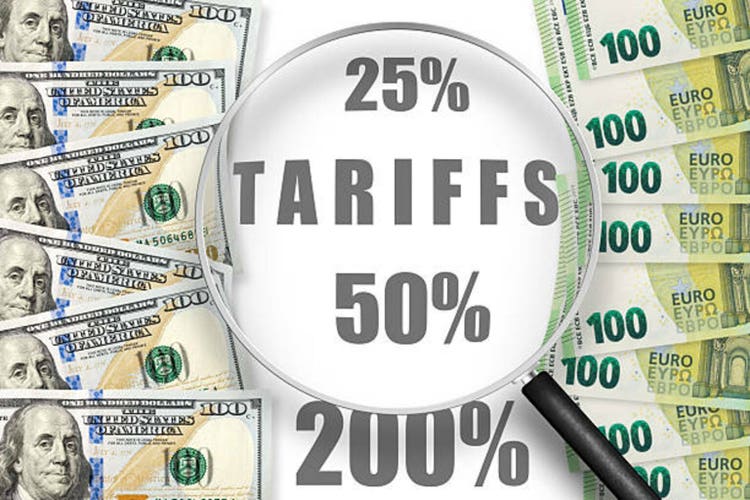 One hundred dollars and euros notes on a white background with word TARIFFS. View through magnifying glass