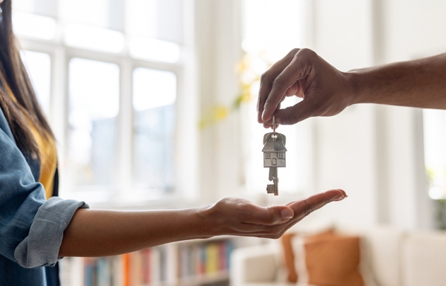 Real estate agent giving the keys of a new house to a woman