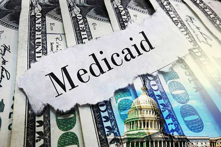 Medicaid newspaper headline on hundred dollar bills with US Capitol in Washington DC