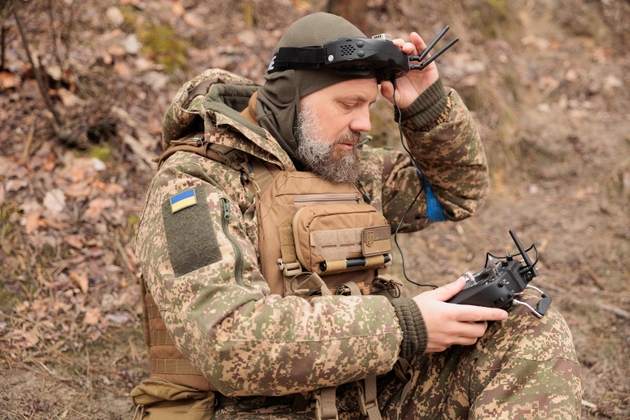 Army operator in FPV glasses controls drone with bomb to drop to enemy.