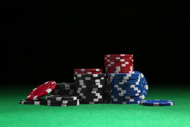 Poker chips on green table against dark background