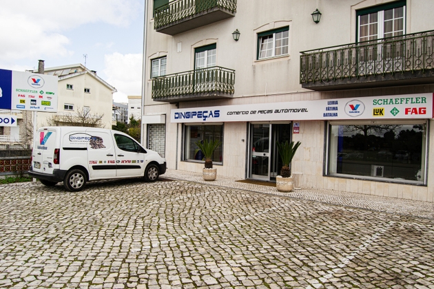Automotive parts store exterior with branded vehicle in Fatima, Portugal