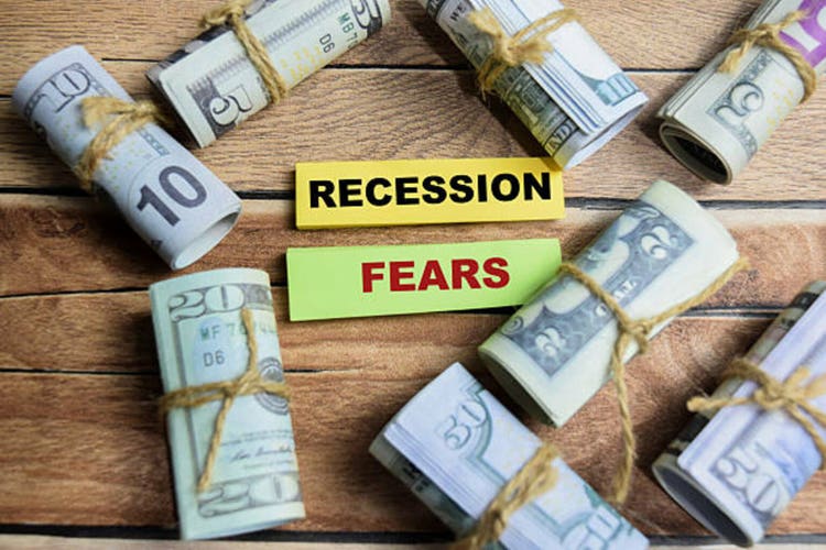 Concept Recession Fears on sticky notes on a wooden table with dollar bills