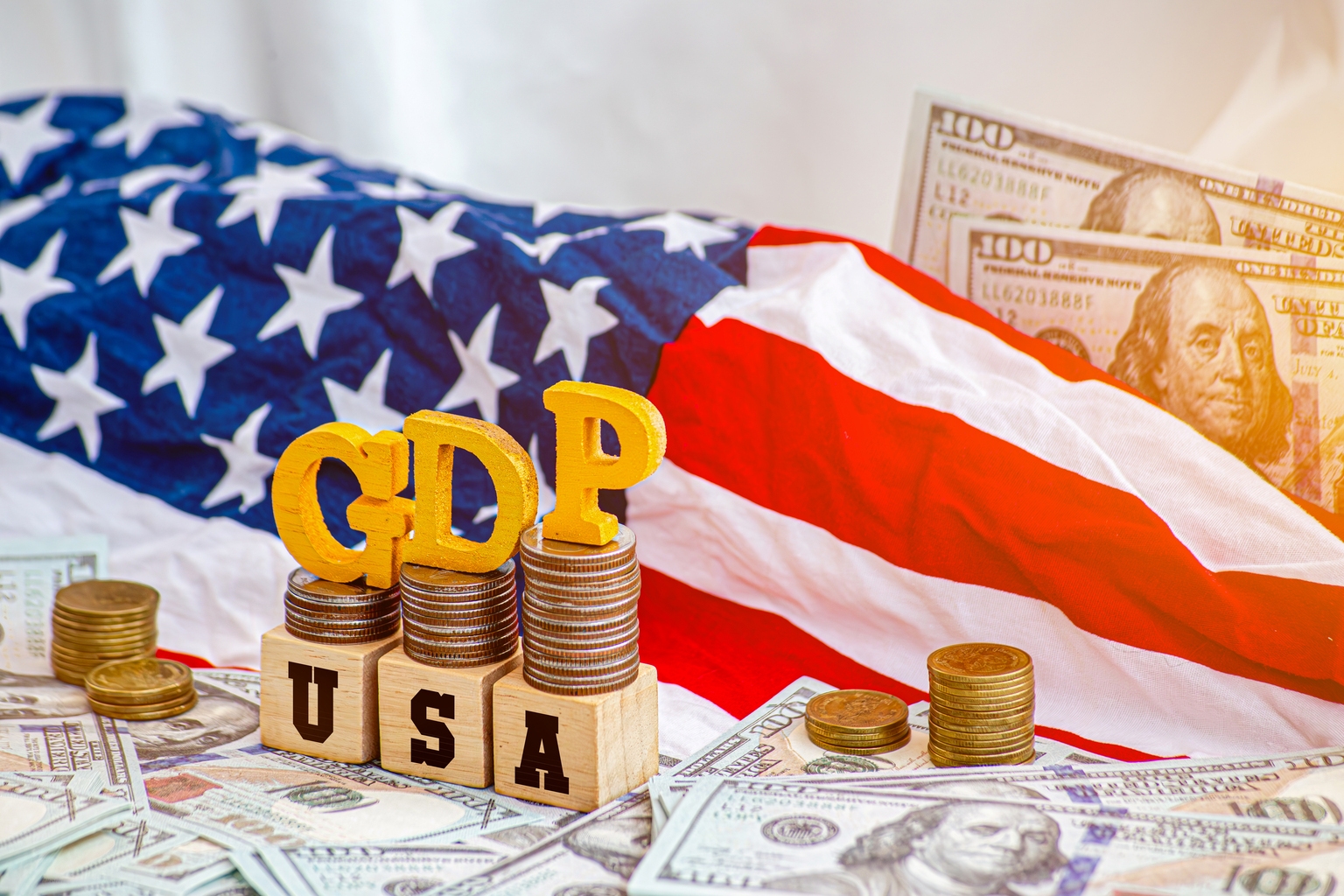 Wooden cube with the word USA and GDP on an American flag background. Business and GDP growth. Gross Domestic Product concept of USA. Counting only income generated within the country.