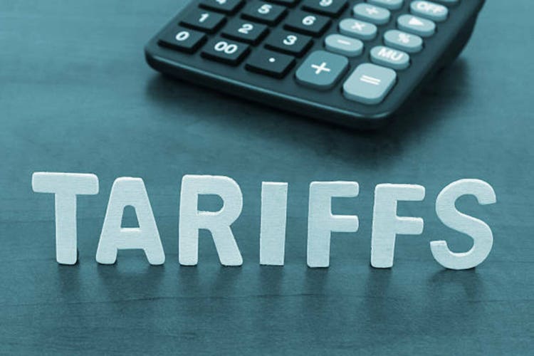 Letters tariffs and calculator on table.