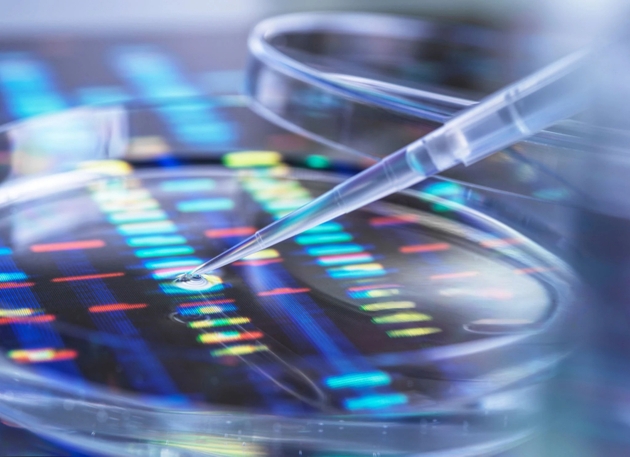 Una pipeta dispensa una gota en un patrón de secuenciación de ADN, lo que ilustra la investigación científica.