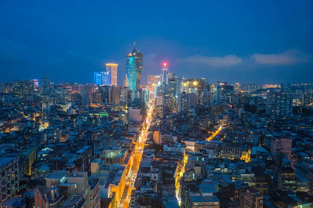 Macau cityscape skyline with hotel and casino skyscraper building at night.