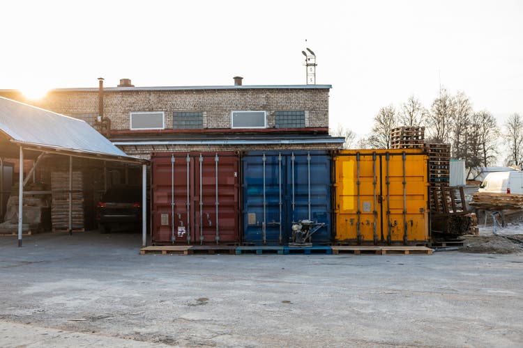Colorful Shipping Containers at Industrial Facility with Brick Building