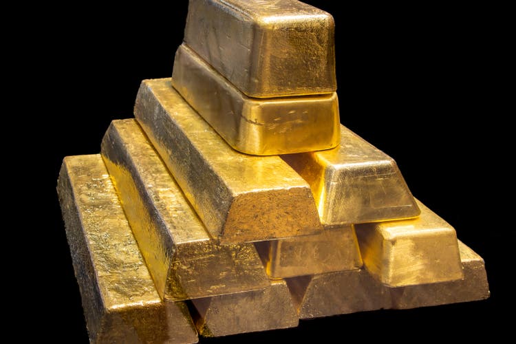 Stack of Shiny 24K real Gold Bullion Bars on Black Background