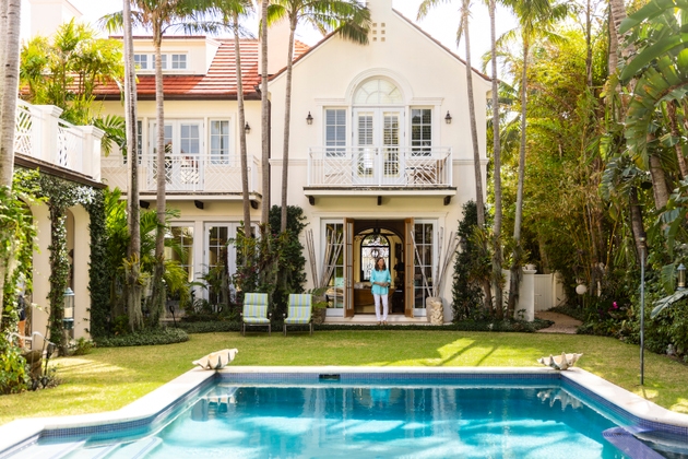 Portrait of senior woman standing in doorway of villa in back yard