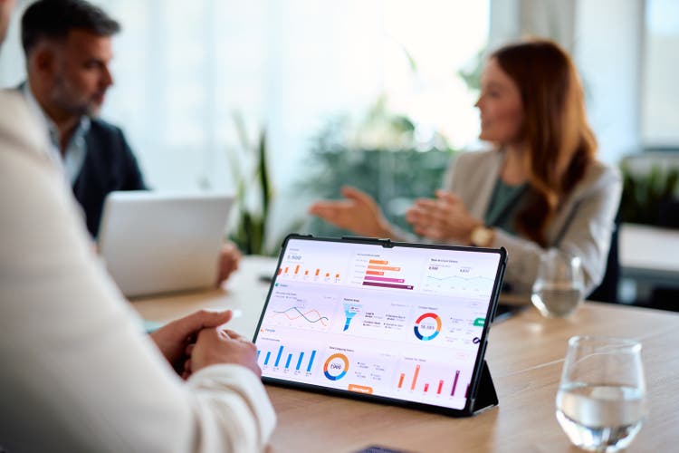 Business team analyzing financial data on a digital tablet during a meeting