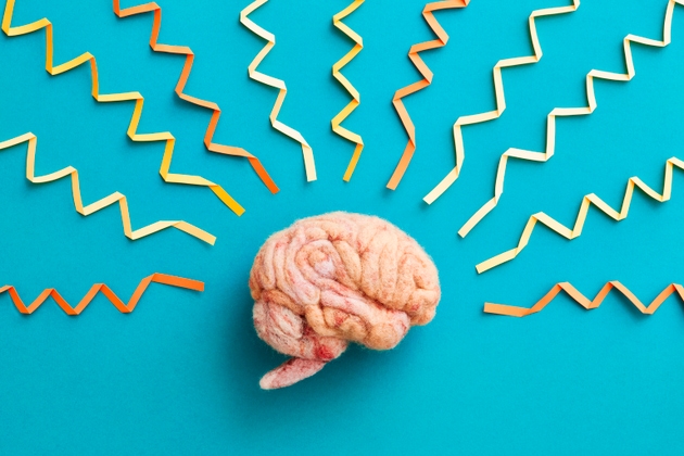 A human brain made of wool with folded paper brainwaves
