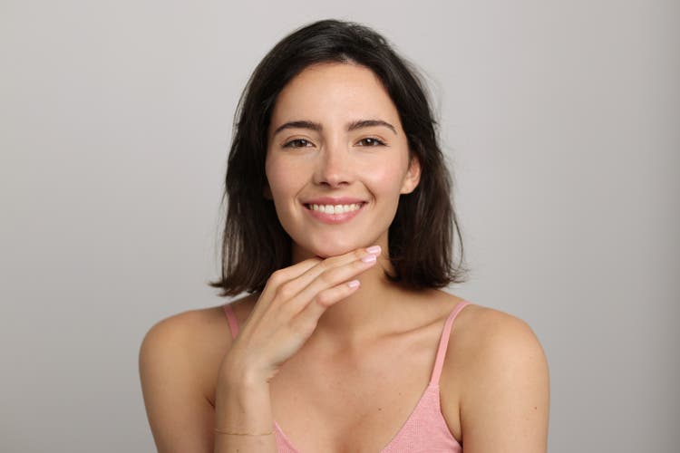 Beauty Portrait of a brunette beautiful smiling woman posing in front of a neutral background - studio photo