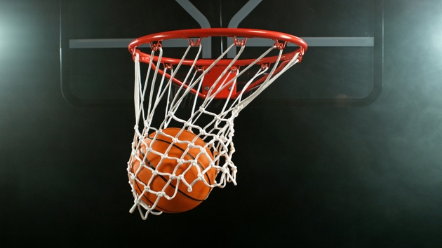 Detail of basketball ball hitting the hoop, top view. Isolated on black background.