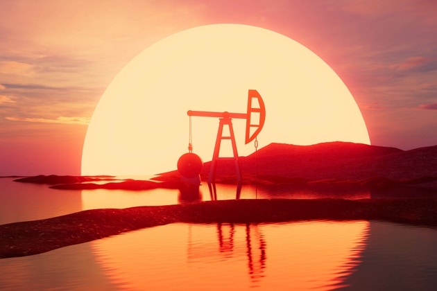 A pump is on a hillside with a sunset in the background