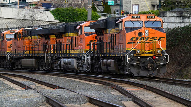 Multiple orange BNSF diesel locomotives with swoosh brand logo