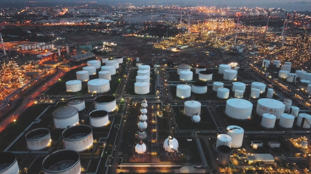 Refinery zone and logistics facility glowing under city lights in oil export terminal in industrial energy complex