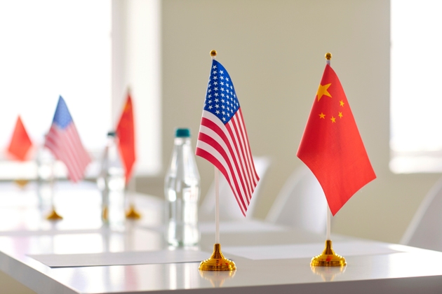 Flags of China and United States of America and papers for signing international agreement.