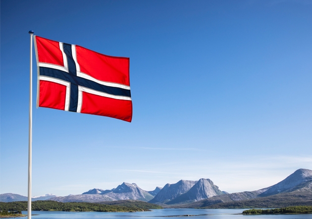 Norwegian national flag in front of blue sky