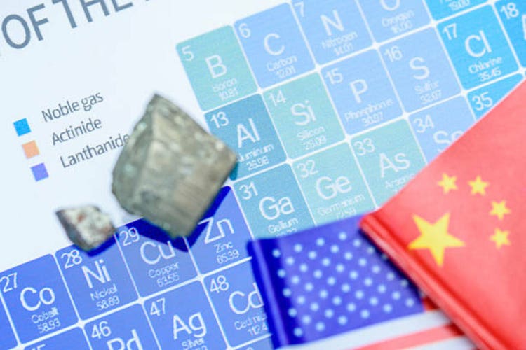  A periodic table, mineral samples (rare earths or refined critical elements) rest on top of the table, symbolizing the raw material control.