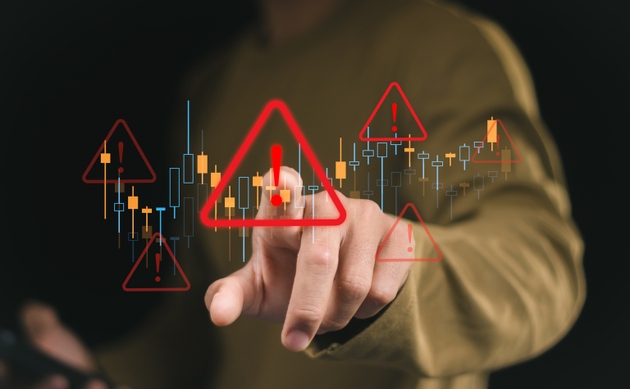 Businessman use smartphone with virtual Business investment risks. stock growth graph with red warning sign for caution in investing economic situation warning, investment in economy crisis.