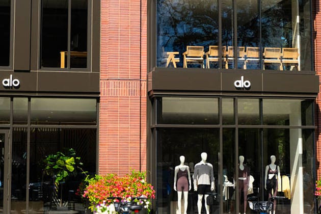 General view of alo yoga logo sign and showcases on a store building facade