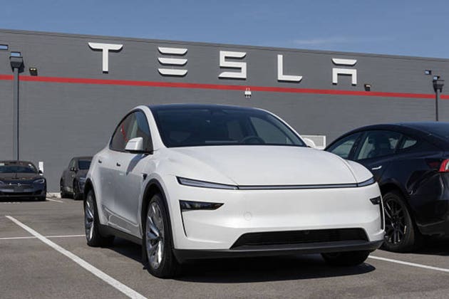 Tesla Model Y display at a dealership. Tesla offers the Model Y with up to 327 miles of driving range. MY:2026