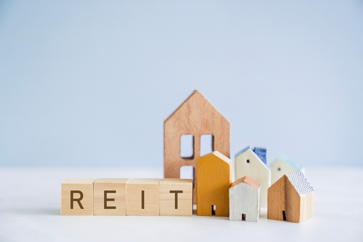 Wooden blocks with REIT and houses, Real Estate Investment Trust concept